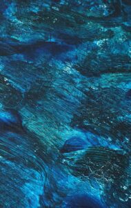A dynamic abstract painting with rich blue tones and textured brushstrokes evokes movement and depth.