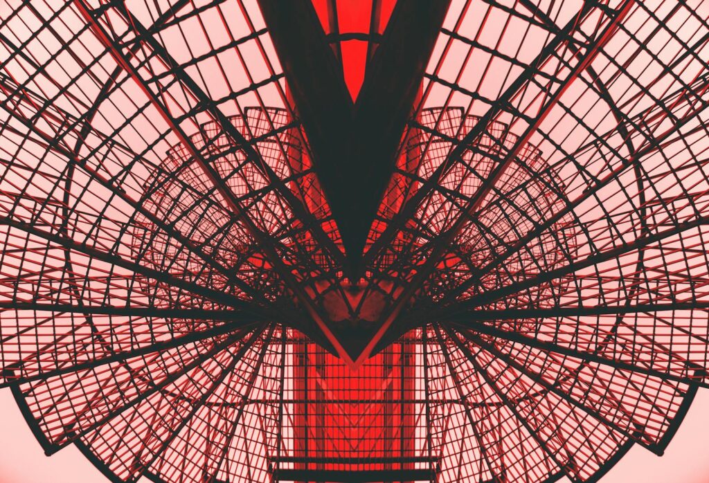 Abstract view of a red geometric architectural structure, showingcasing modern design and symmetry.