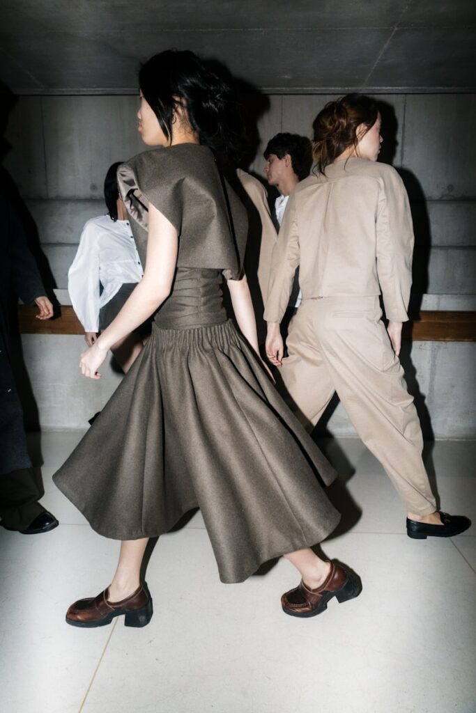 Models walk during a fashion show backstage.