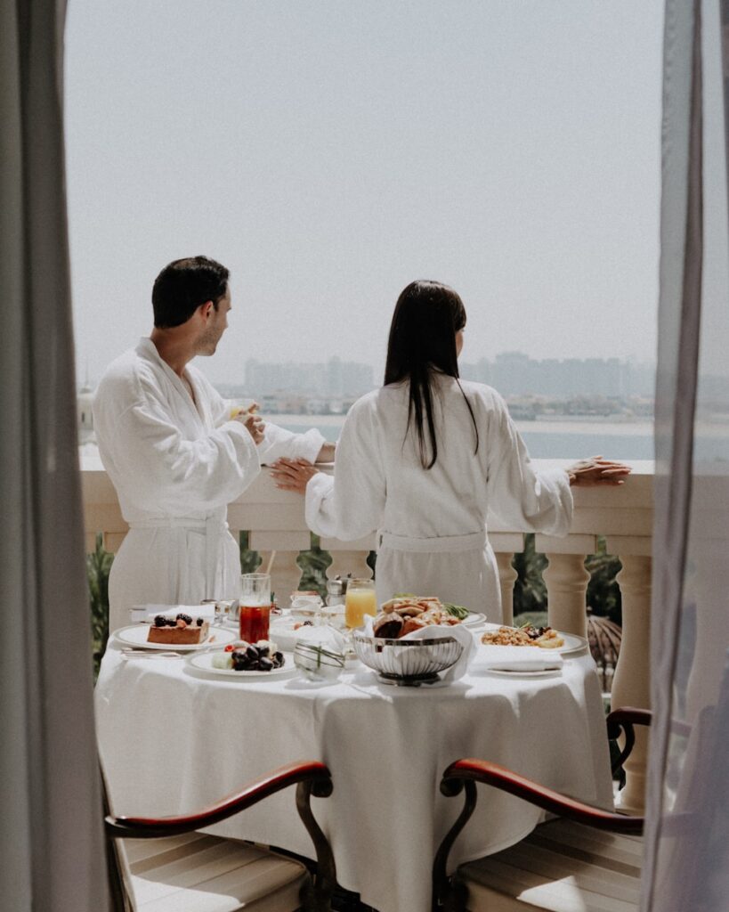 Couple enjoys breakfast on a balcony with a view.