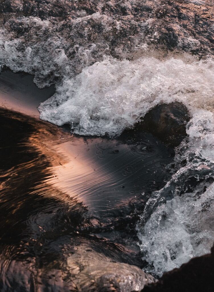 Water flows vigorously over a dark surface.