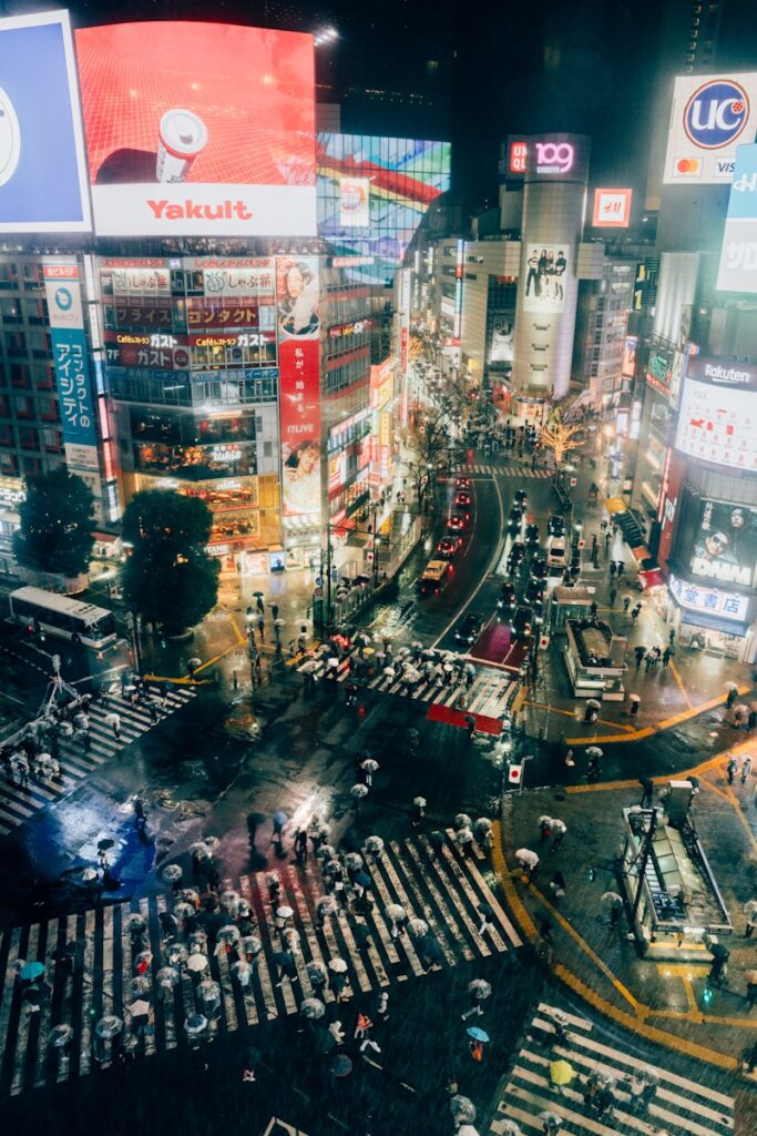 Busy shibuya crossing at night with many people.