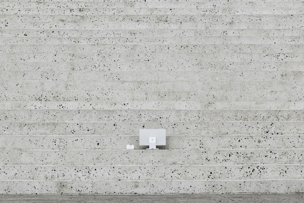 A man walking down a street next to a cement wall