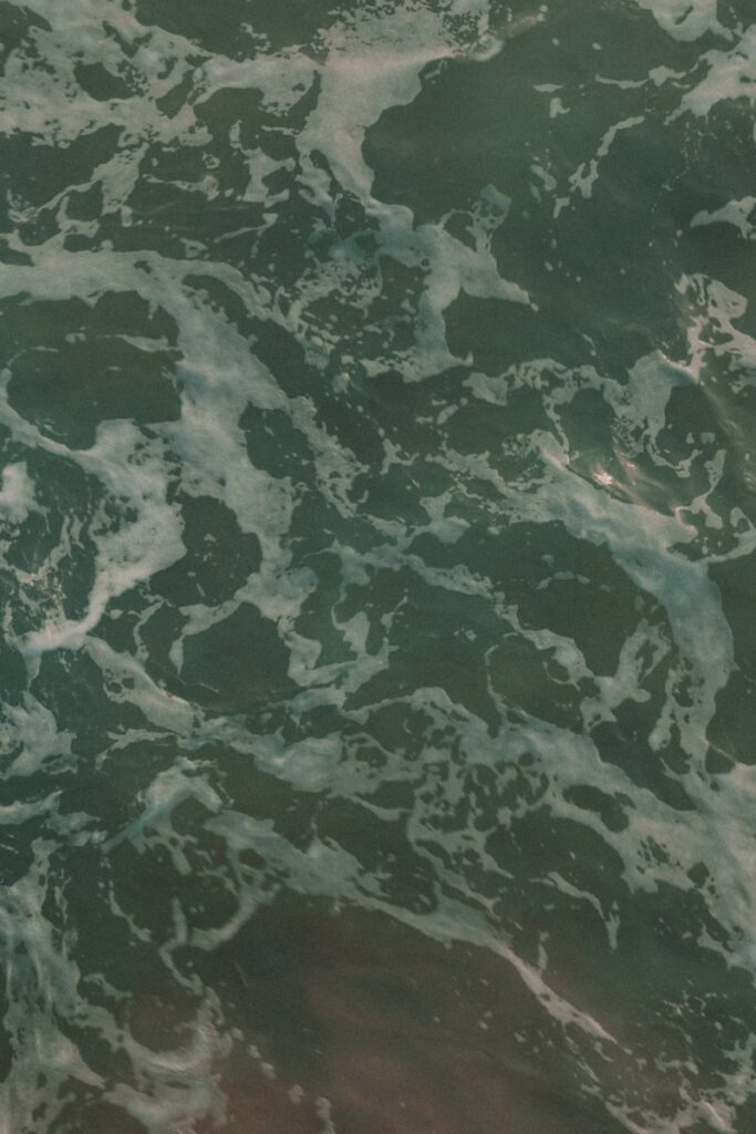 Foamy ocean water swirls around, up close.