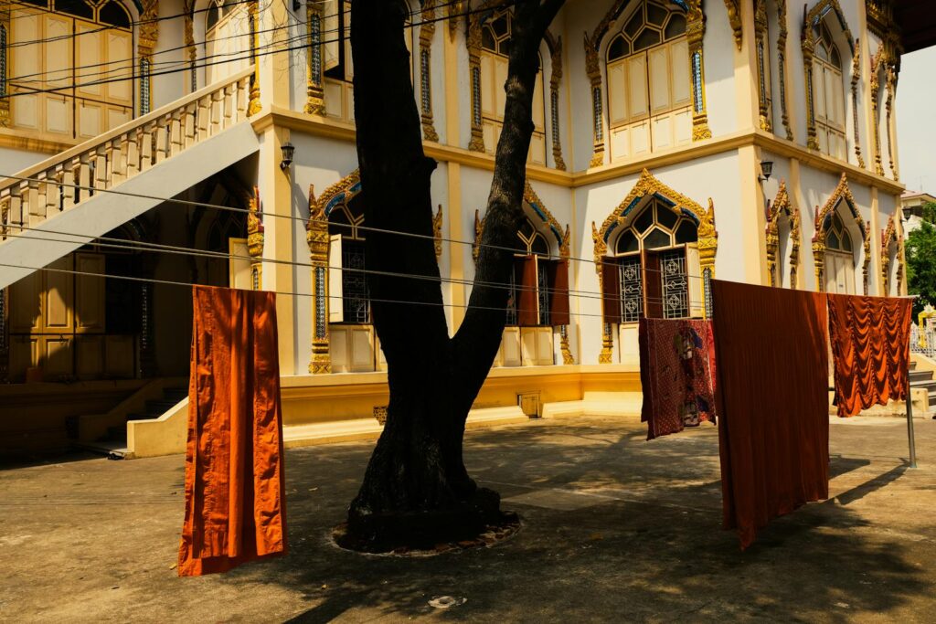 Monk robes drying on clotheslines at a temple in Bangkok, reflecting cultural tradition.