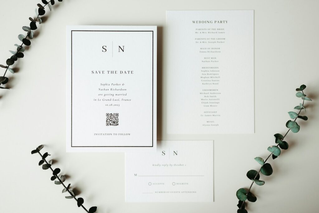 Wedding invitations and stationery displayed with greenery.