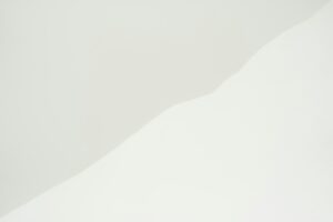 a man riding a snowboard down the side of a snow covered slope