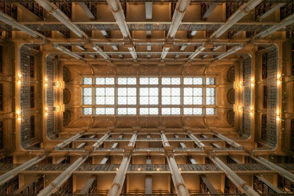 Looking up through a beautiful, ornate building's ceiling.