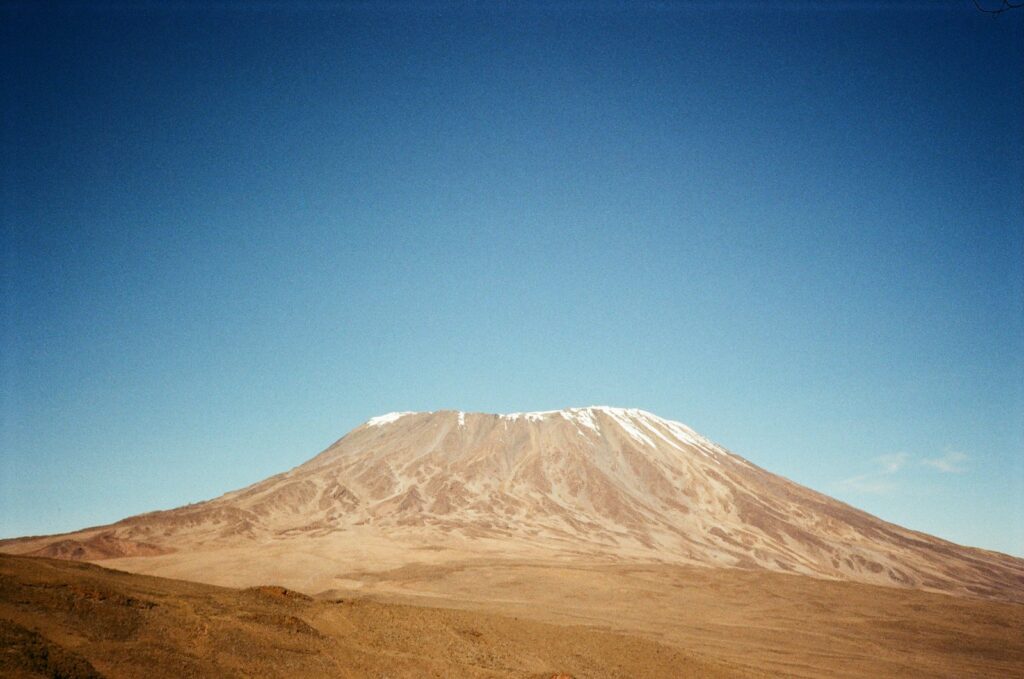 A mountain stands tall under a bright blue sky.