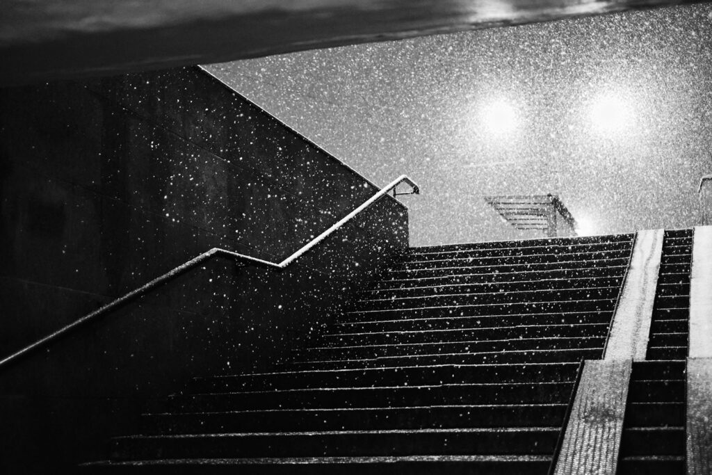 Rain falls on outdoor stairs at night.