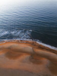 Aerial view of the ocean meeting the beach.