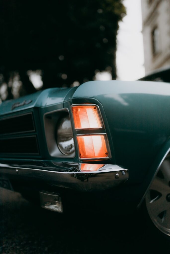 Close-up of a vintage blue car's headlight.