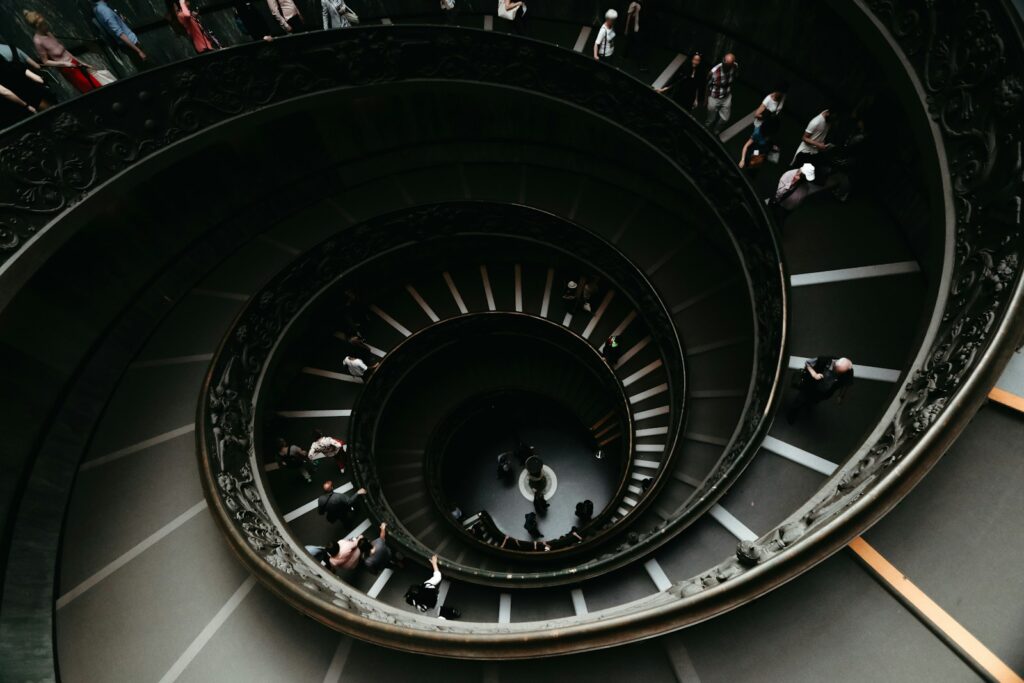 People walk down a spiraling staircase.