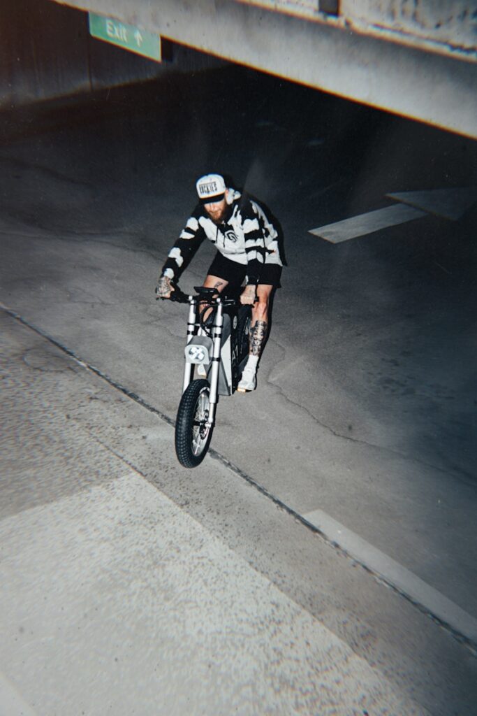A man riding a bike down the middle of a street