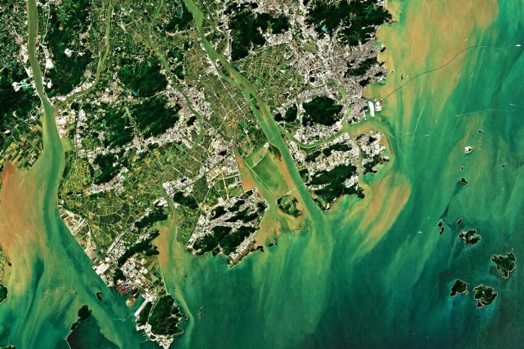 aerial photography of green field surrounded with body of water