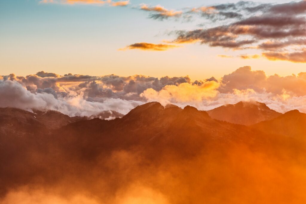 landscape photography of mountains with cloudy skies during golden hour