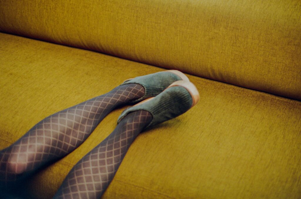Legs in patterned tights are resting.