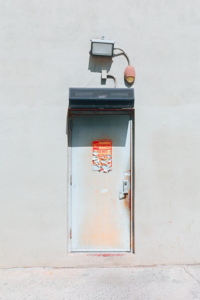 Weathered metal door with equipment above.