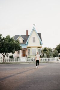 Man stands in front of a colorful house.