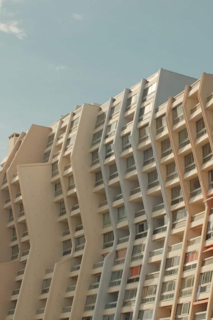 Wavy building facade against a clear blue sky.