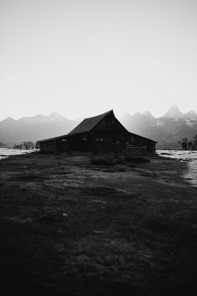 An old barn stands peacefully in the mountains.
