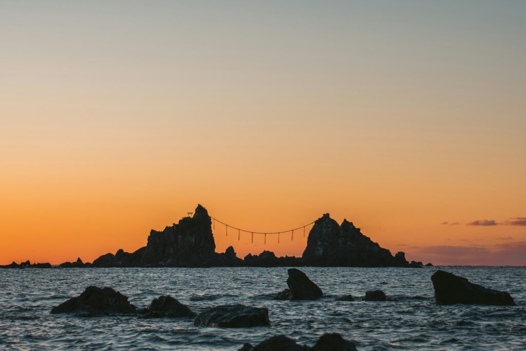 A sunrise lights up the rocks over the sea.